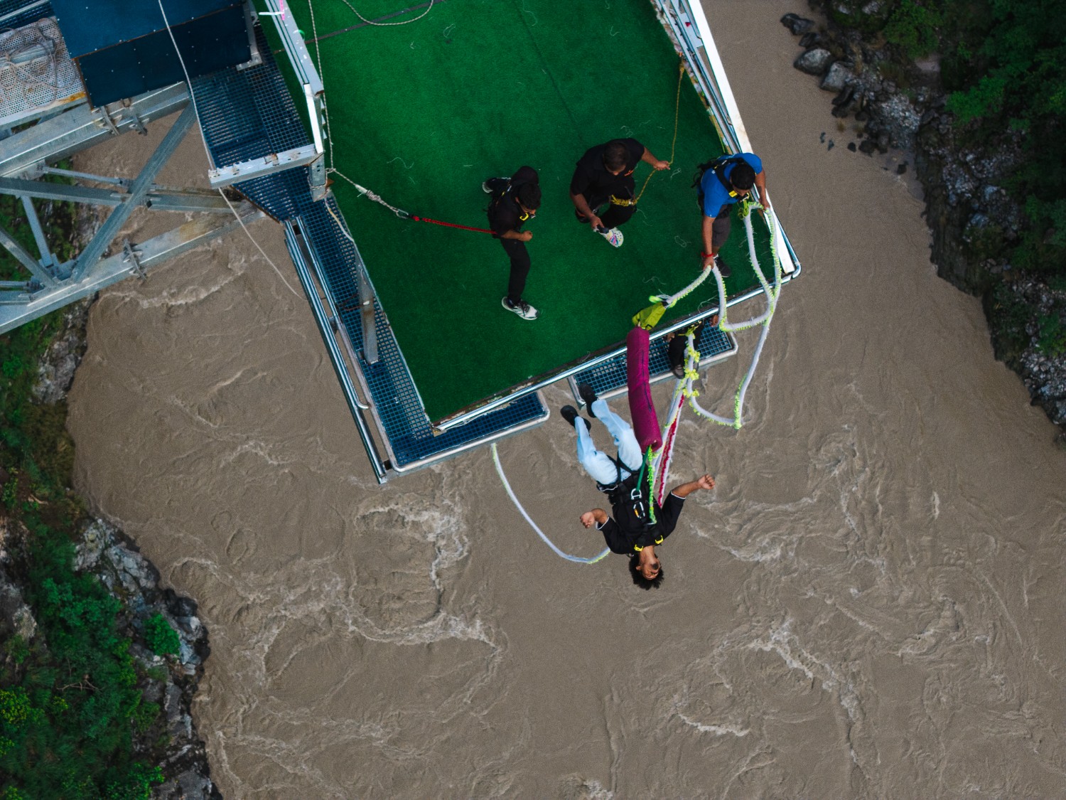 Bungee jumper suspended above the river at Maa Ganga Bungy