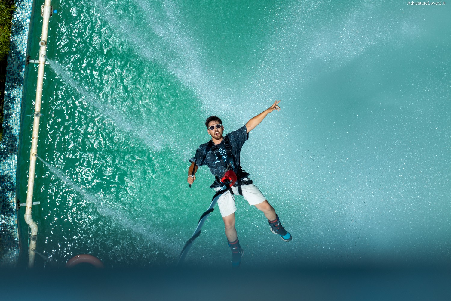 Splash bungee jumping in Rishikesh with a participant descending towards turquoise water.